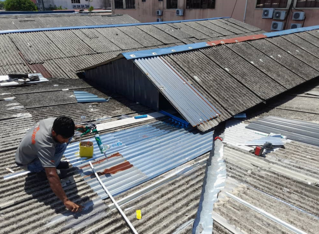 worker on rooftop working on rainy season home waterproofing
