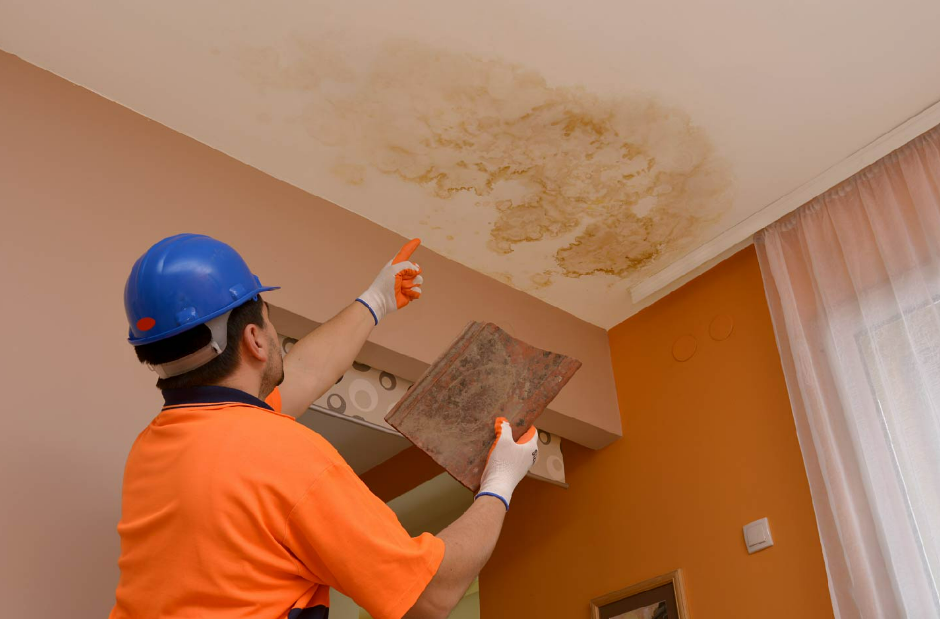 a man pointing to wall with water damage