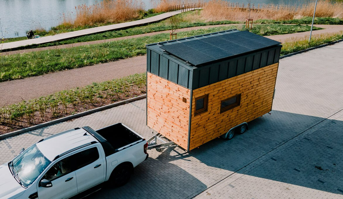 a pickup truck pulling a tiny house